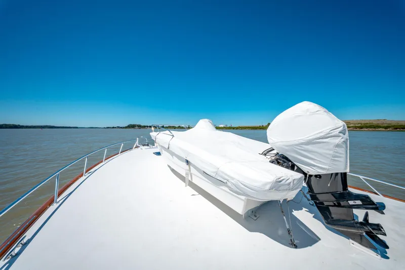  Yacht Photos Pics 1998 Donzi R73 yacht deck with covered equipment, cruising on a calm river under clear blue skies.