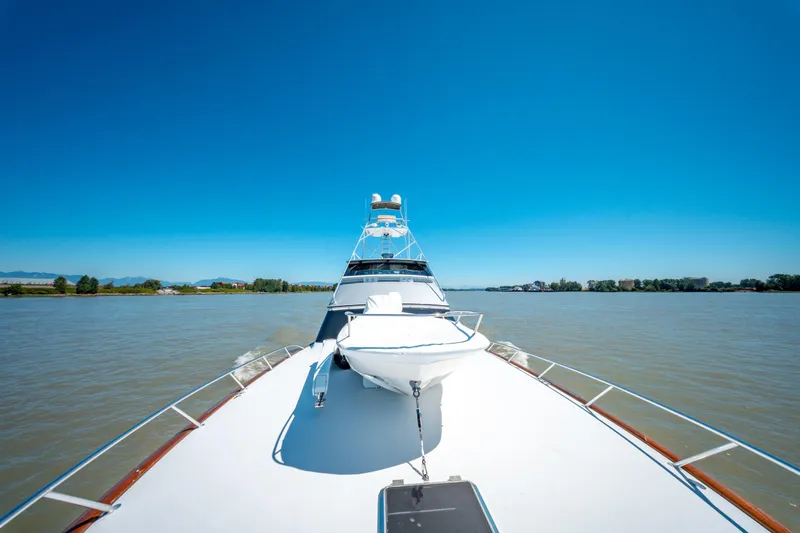  Yacht Photos Pics 1998 Donzi R73 yacht cruising on a calm river under clear blue skies.