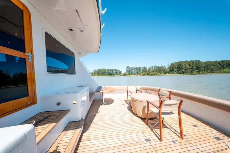  Yacht Photos Pics Luxurious 1998 Donzi R73 yacht deck with seating, overlooking serene water and lush greenery.