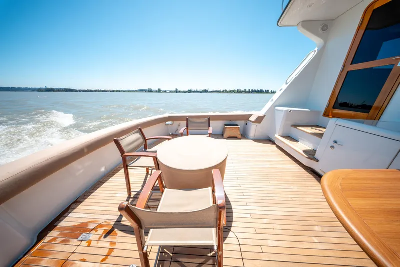  Yacht Photos Pics 1998 Donzi R73 yacht deck with wooden chairs and table, cruising on a sunny day.