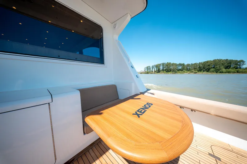  Yacht Photos Pics 1998 Donzi R73 yacht deck with wooden table, scenic river view, and clear blue sky.