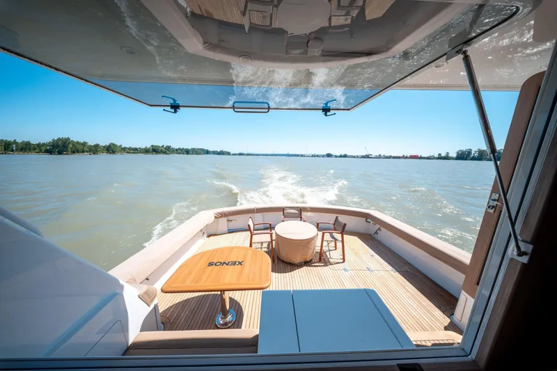  Yacht Photos Pics 1998 Donzi R73 yacht deck with seating, table, and scenic water view.