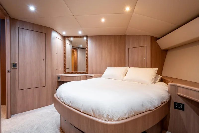  Yacht Photos Pics Luxurious bedroom interior of 1998 Donzi R73 yacht with elegant wood paneling and cozy lighting.