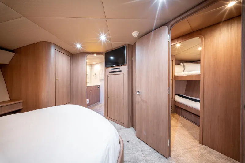  Yacht Photos Pics Interior of 1998 Donzi R73 yacht featuring cozy wood-paneled cabin with bunk beds and TV.