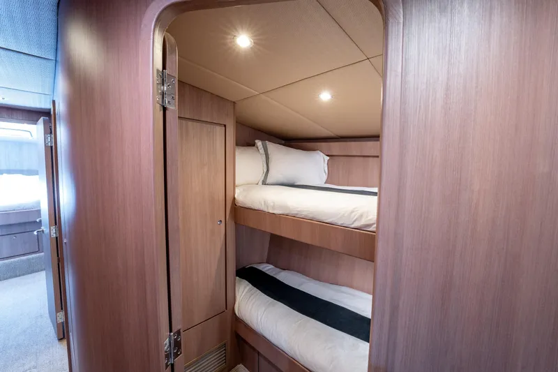  Yacht Photos Pics 1998 Donzi R73 yacht interior with cozy wooden bunk beds and soft lighting.