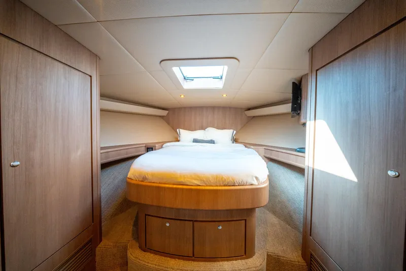  Yacht Photos Pics Luxurious cabin interior of 1998 Donzi R73 yacht with cozy bed and wooden finish.