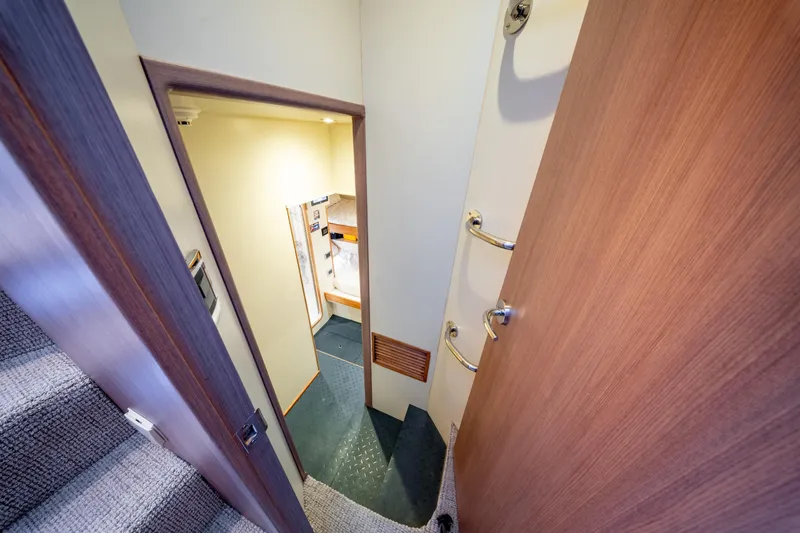  Yacht Photos Pics Interior view of 1998 Donzi R73 yacht, featuring a narrow hallway and wooden door.