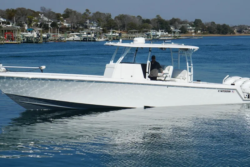  Yacht Photos Pics 2024 Contender 39 ST boat cruising on a calm blue lake near a marina.