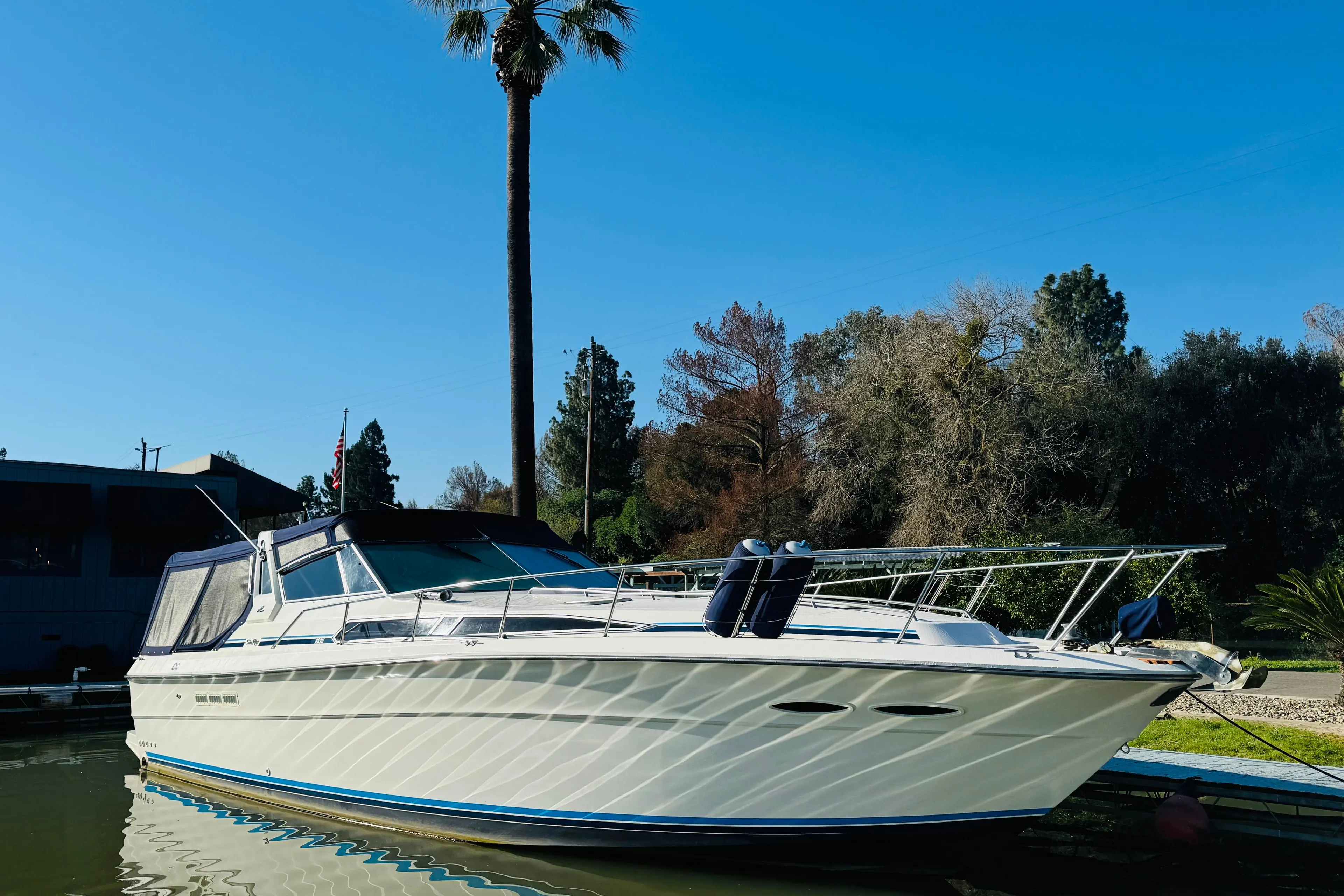 1989 Sea Ray 390 Express Cruiser docked under clear blue sky.