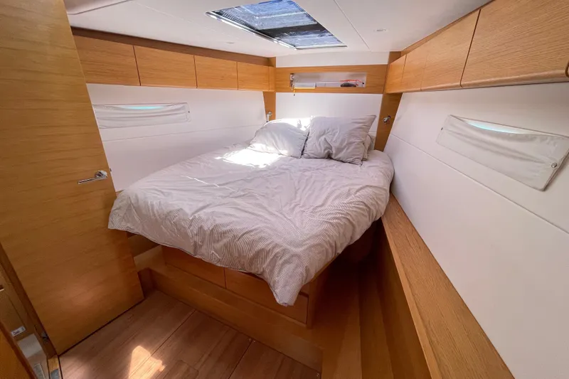  Yacht Photos Pics Luxurious cabin interior of 2018 X-Yachts X4.9 with cozy bed and wooden accents.