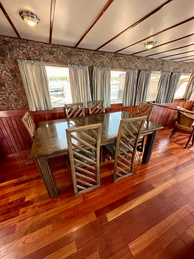 Boatel I Yacht Photos Pics Dining area on a 1998 Custom 65 Foot Trawler with wooden floors and elegant decor.