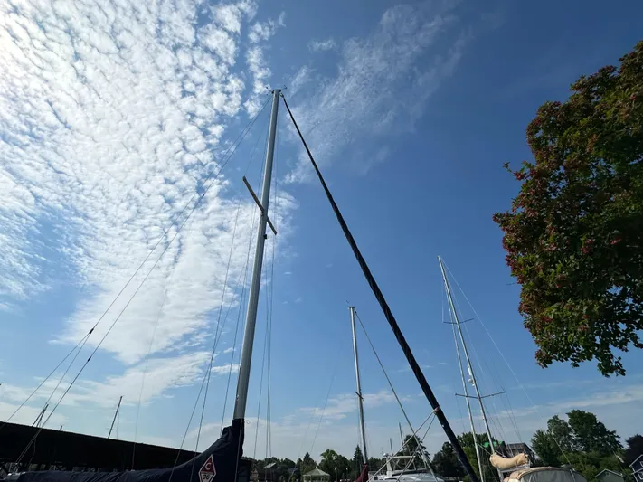Wakes Yacht Photos Pics Mast of a 2005 Catalina 36 MkII sailboat against a blue sky with clouds.
