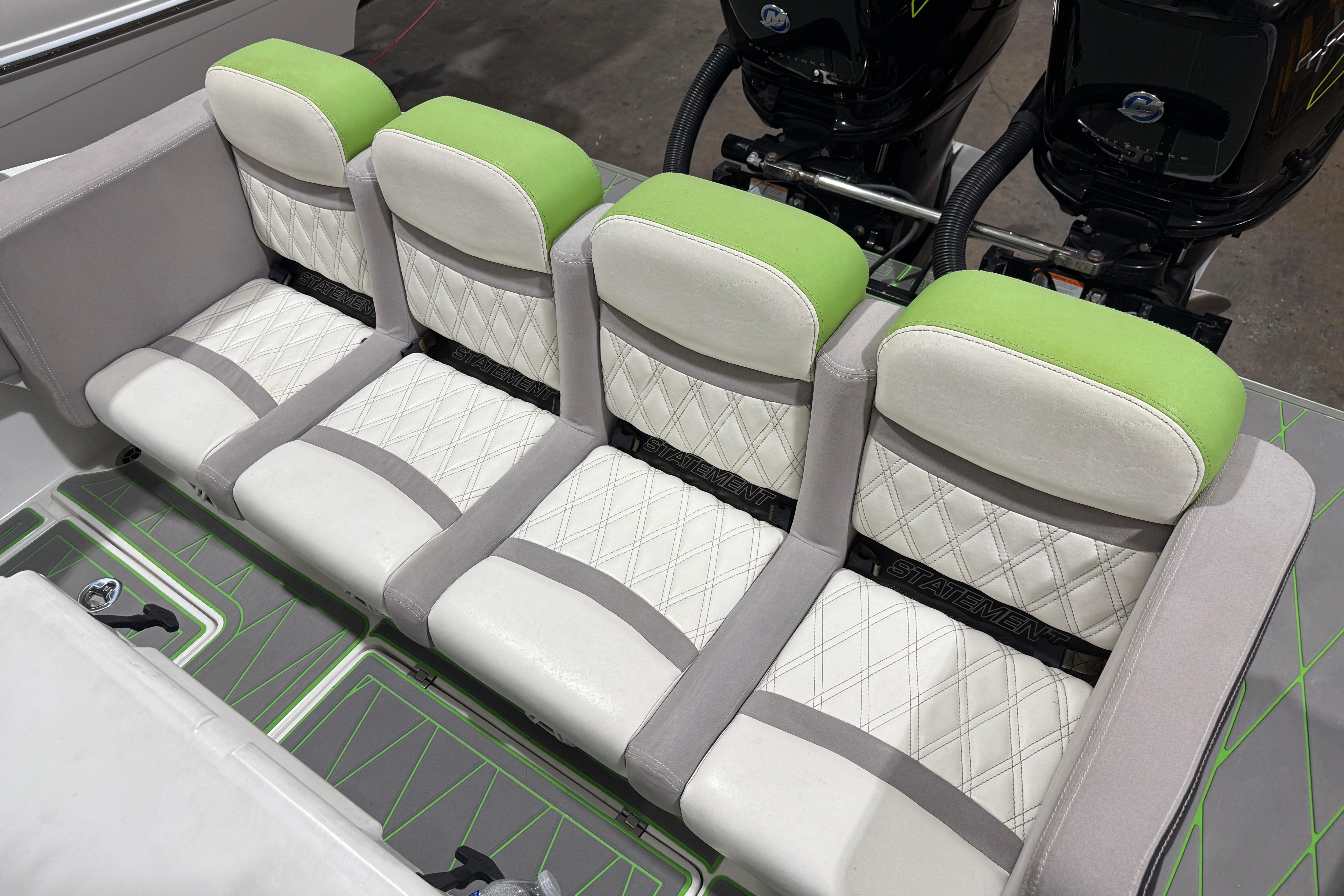 Four cushioned seats on a 2017 Statement 350 Open boat, featuring green and white upholstery.