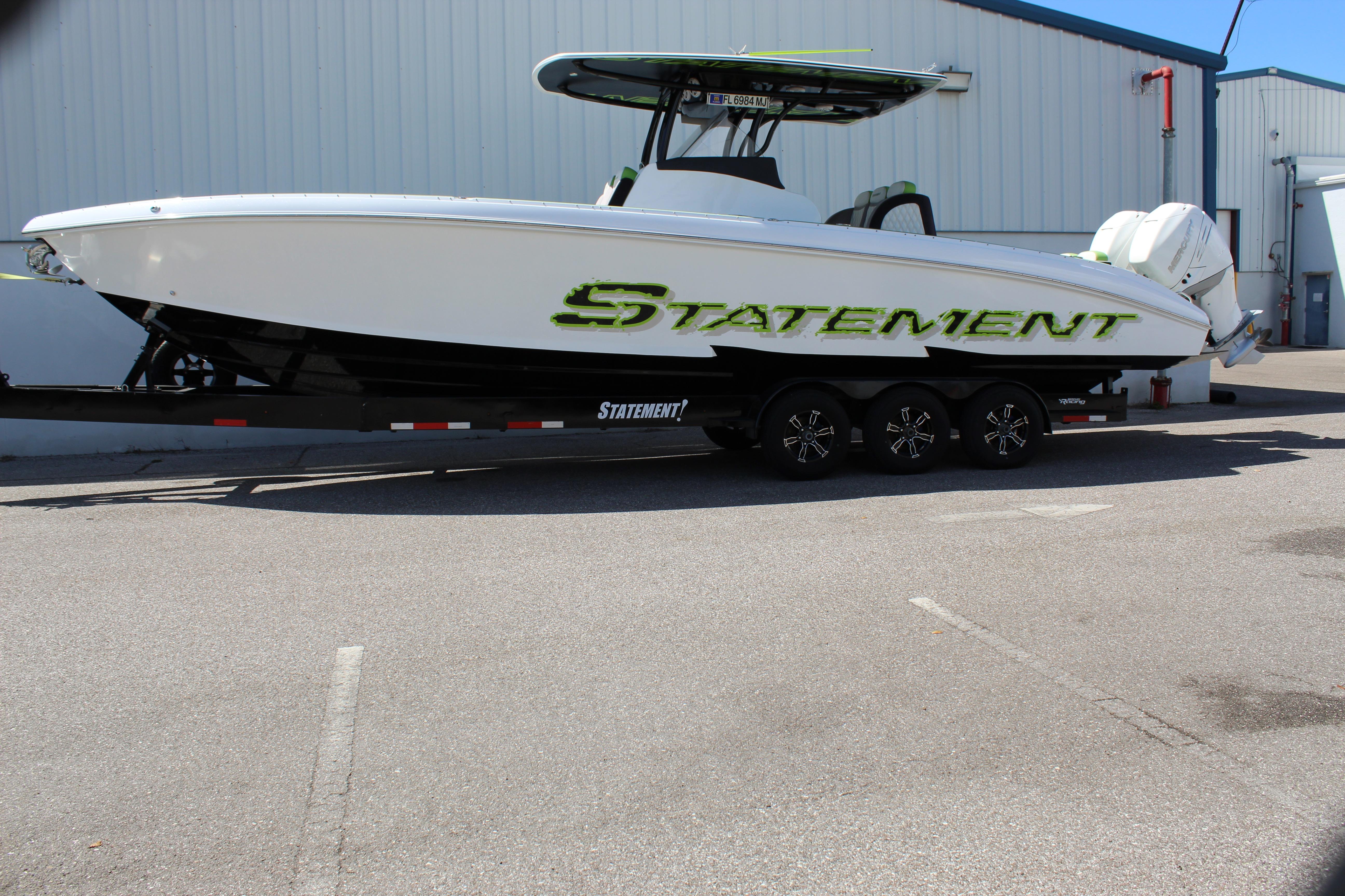 2017 Statement 350 Open boat on trailer, parked outdoors near industrial building.