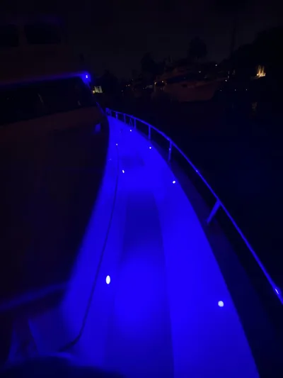 Sue Carolyn Yacht Photos Pics 2003 Hargrave Sky Lounge yacht with vibrant blue deck lighting at night.