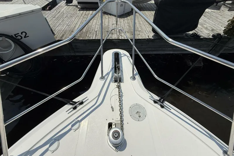  Yacht Photos Pics Bow view of 1995 Sea Ray 550 Sedan Bridge at dock, featuring anchor chain and railings.
