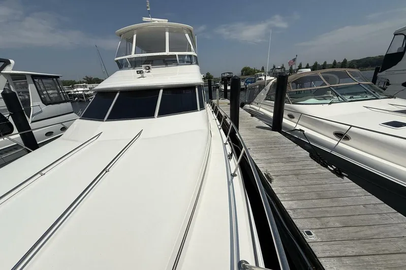  Yacht Photos Pics 1995 Sea Ray 550 Sedan Bridge yacht docked at marina, sunny day.