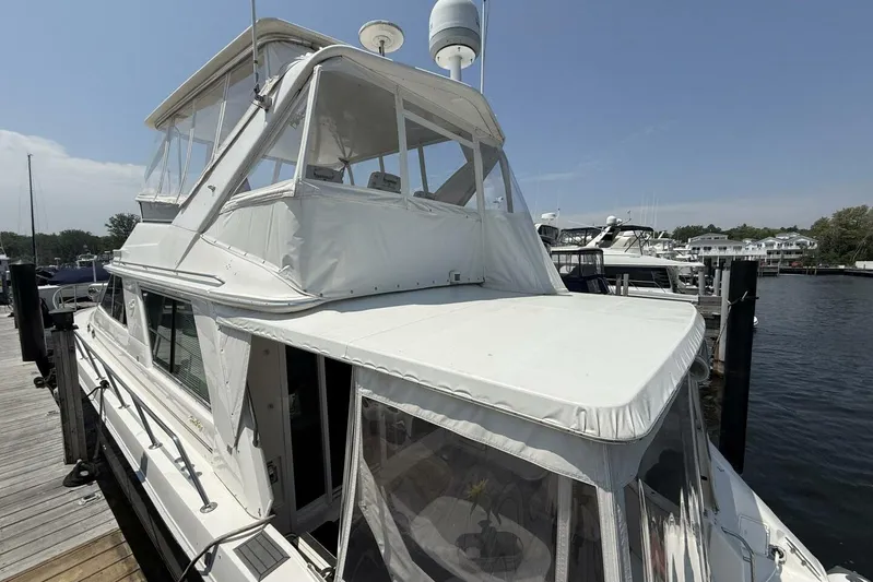  Yacht Photos Pics 1995 Sea Ray 550 Sedan Bridge yacht docked at marina, featuring white canopy and sleek design.