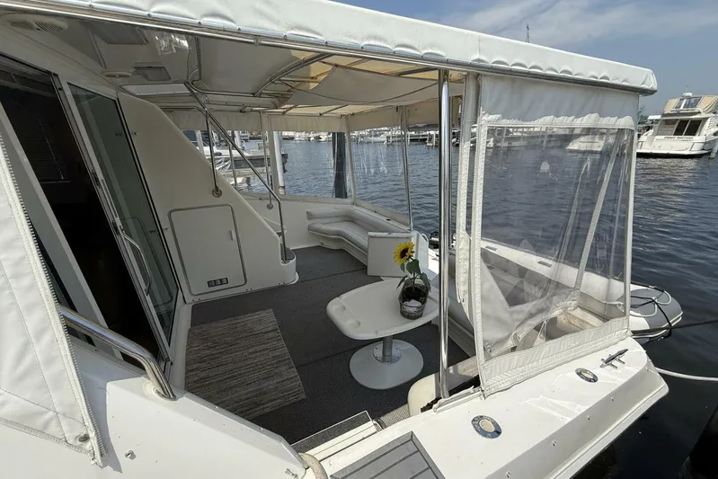  Yacht Photos Pics 1995 Sea Ray 550 Sedan Bridge yacht interior with seating and table, docked at marina.