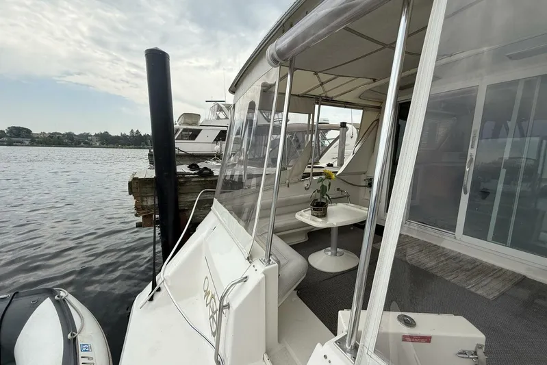  Yacht Photos Pics 1995 Sea Ray 550 Sedan Bridge yacht docked, featuring a cozy outdoor seating area with a table.