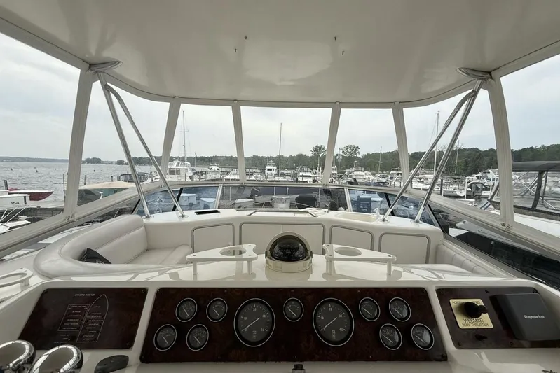  Yacht Photos Pics 1995 Sea Ray 550 Sedan Bridge helm with marina view, featuring gauges and navigation equipment.