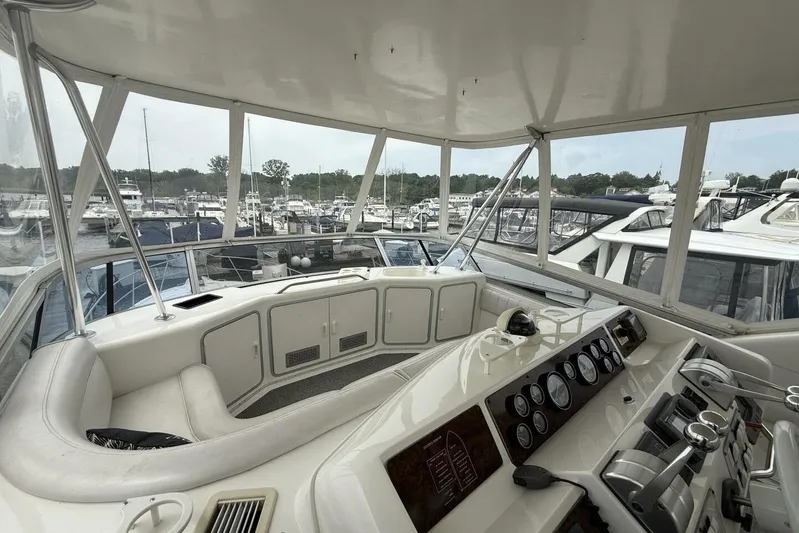  Yacht Photos Pics 1995 Sea Ray 550 Sedan Bridge helm with marina view, featuring control panel and seating area.