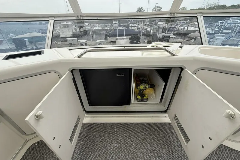  Yacht Photos Pics 1995 Sea Ray 550 Sedan Bridge interior with open storage compartments and marina view.