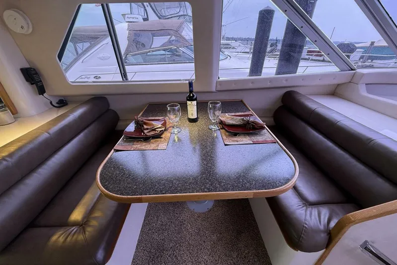  Yacht Photos Pics Dining area inside 1995 Sea Ray 550 Sedan Bridge yacht with table setting and wine.