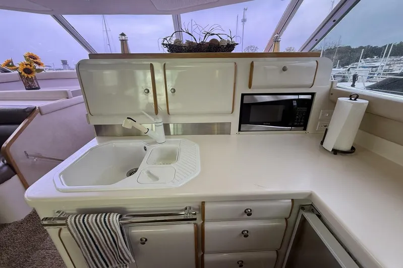  Yacht Photos Pics 1995 Sea Ray 550 Sedan Bridge kitchen with sink, microwave, and cabinets.