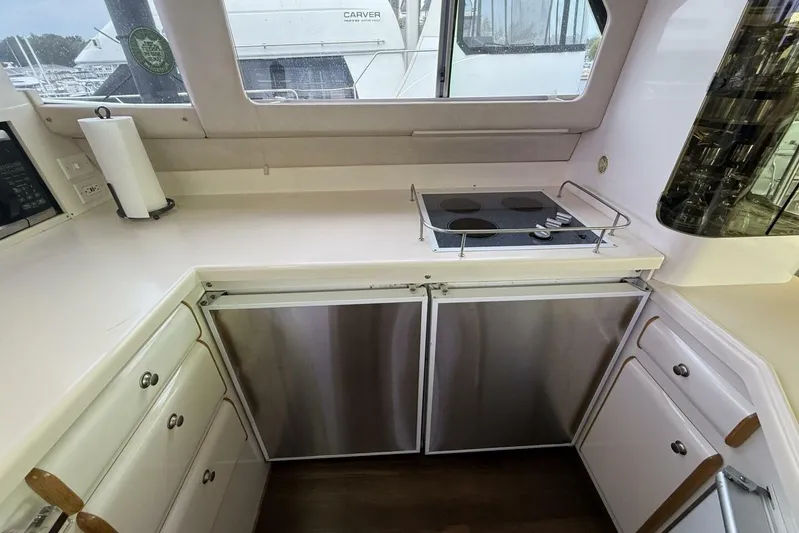  Yacht Photos Pics 1995 Sea Ray 550 Sedan Bridge kitchen with stove, cabinets, and window view.