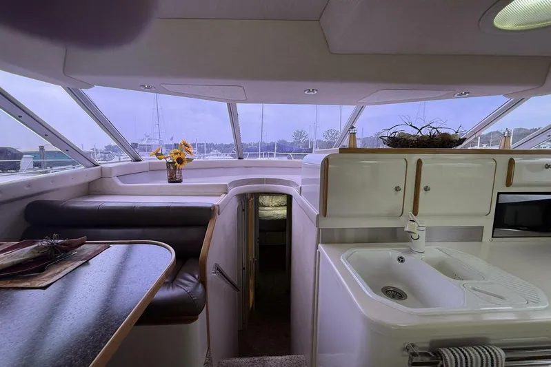  Yacht Photos Pics Interior of a 1995 Sea Ray 550 Sedan Bridge yacht with kitchen and seating area.