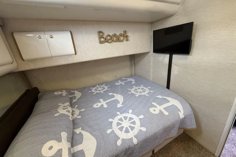  Yacht Photos Pics Cozy bedroom in 1995 Sea Ray 550 Sedan Bridge with nautical-themed bedding and wall decor.