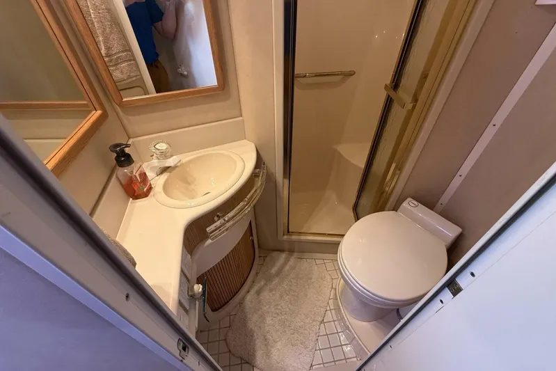  Yacht Photos Pics Bathroom interior of 1995 Sea Ray 550 Sedan Bridge yacht, featuring sink, toilet, and shower.