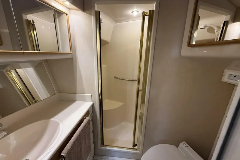  Yacht Photos Pics Bathroom interior of 1995 Sea Ray 550 Sedan Bridge yacht, featuring shower and sink.