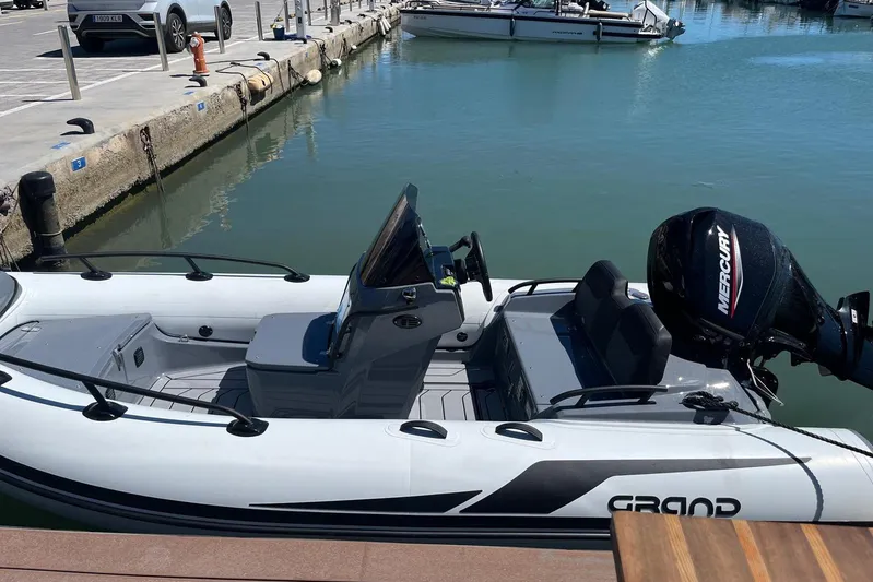 Perseus Yacht Photos Pics Inflatable boat with Mercury engine docked at marina, clear water, sunny day.