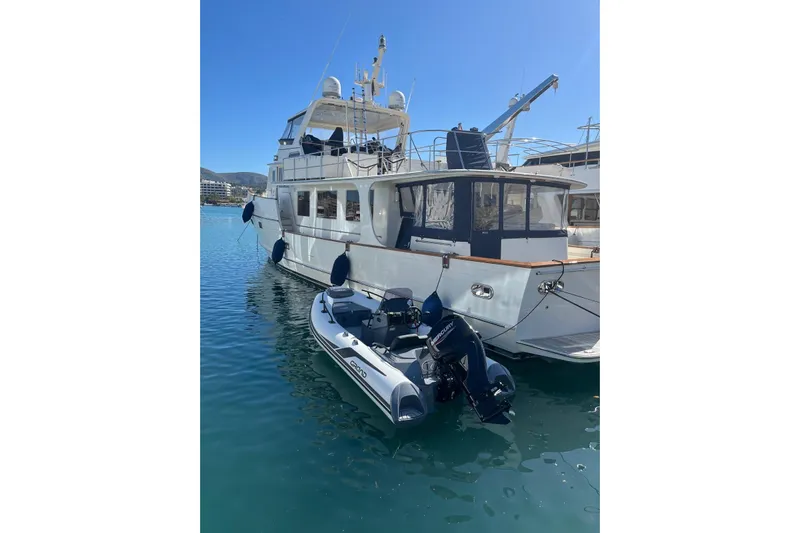 Perseus Yacht Photos Pics Luxury 2004 Fleming 75 yacht docked with inflatable boat in sunny marina.