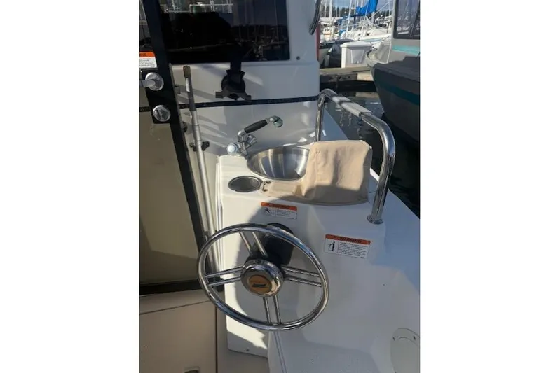 Yacht Photos Pics 2016 Cutwater 28 boat helm with steering wheel and sink, docked at marina.
