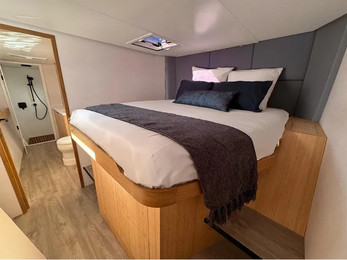  Yacht Photos Pics Luxurious bedroom in 2025 Ocean Renegade R6 yacht with modern decor and ensuite bathroom.