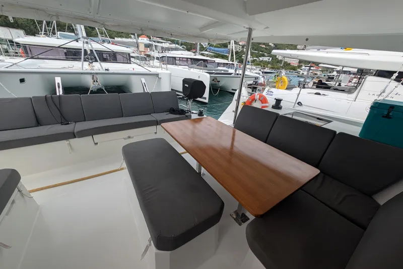 Maho Yacht Photos Pics 2021 Fountaine Pajot Astrea 42 Catamaran with spacious outdoor seating and wooden table.