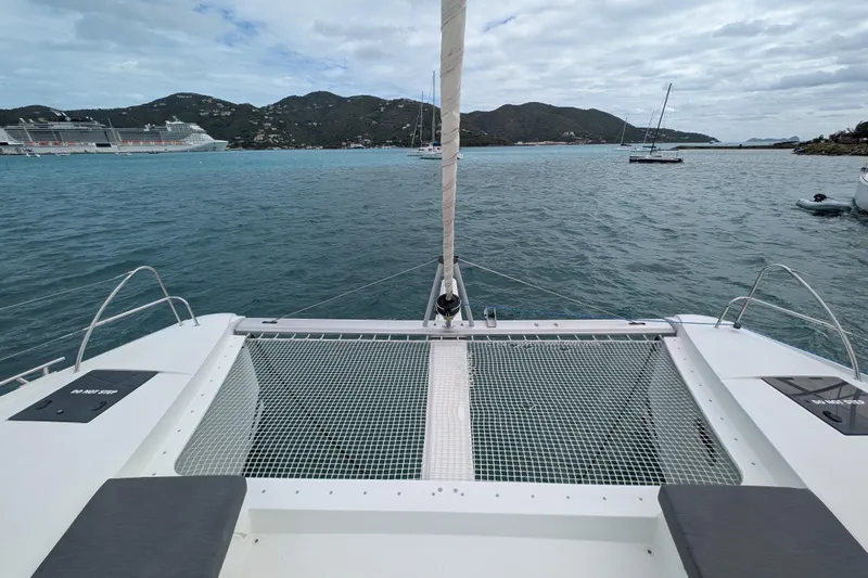 Maho Yacht Photos Pics 2021 Fountaine Pajot Astrea 42 Catamaran on serene waters with scenic island backdrop.