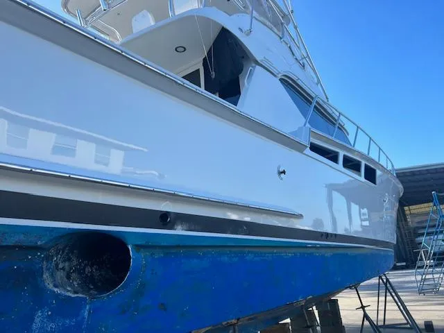  Yacht Photos Pics 2002 Hatteras 55 Convertible yacht on dry dock, showcasing sleek design and blue hull.