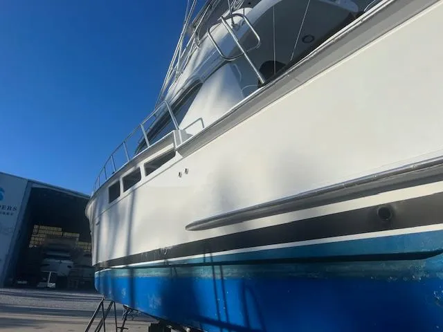  Yacht Photos Pics 2002 Hatteras 55 Convertible yacht with blue hull, docked under clear sky.