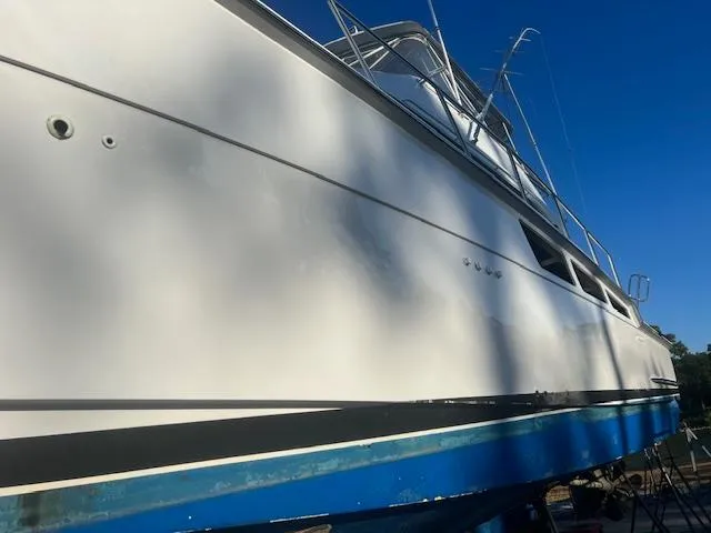  Yacht Photos Pics 2002 Hatteras 55 Convertible yacht on dry dock, side view under clear blue sky.
