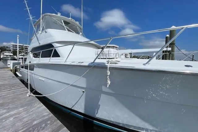  Yacht Photos Pics 2002 Hatteras 55 Convertible yacht docked under a clear blue sky.