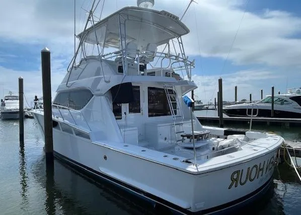  Yacht Photos Pics 2002 Hatteras 55 Convertible yacht docked at marina under cloudy sky.