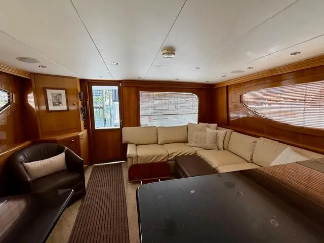  Yacht Photos Pics Luxurious interior of 2002 Hatteras 55 Convertible yacht with plush seating and elegant wood finishes.