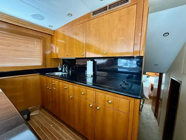  Yacht Photos Pics Luxurious kitchen interior of 2002 Hatteras 55 Convertible yacht with wooden cabinetry.