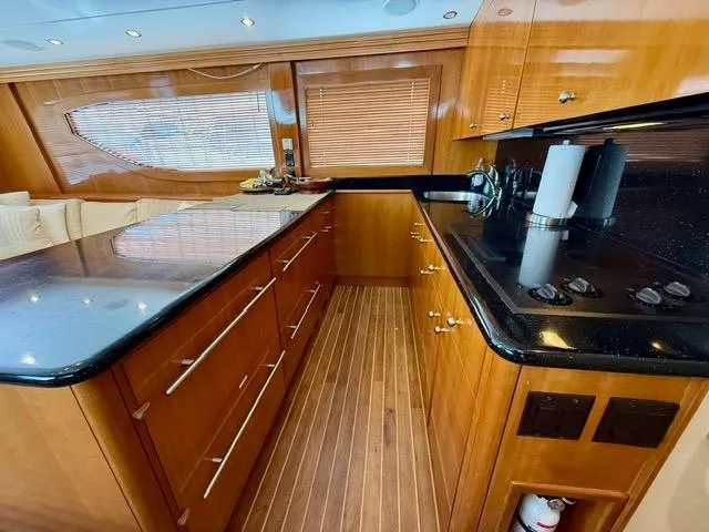  Yacht Photos Pics Luxurious kitchen interior of 2002 Hatteras 55 Convertible yacht with wood cabinetry and modern appliances.