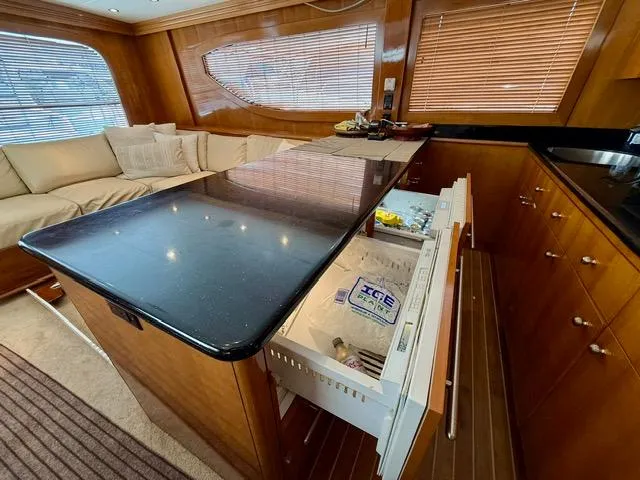  Yacht Photos Pics Luxurious interior of 2002 Hatteras 55 Convertible yacht with modern kitchen and seating area.