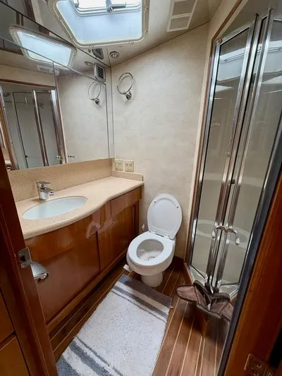  Yacht Photos Pics Bathroom interior of 2002 Hatteras 55 Convertible yacht with shower and wooden cabinetry.